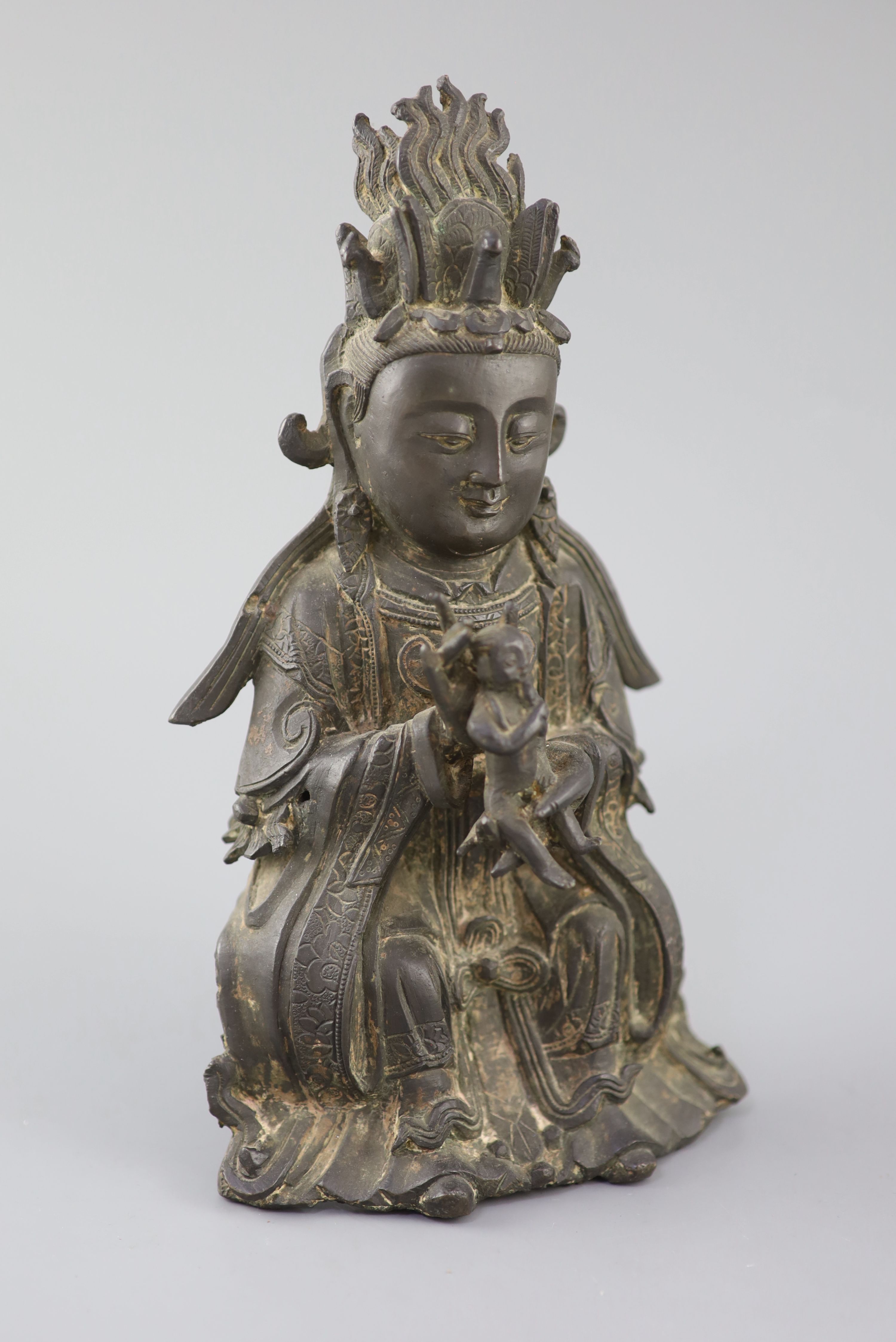 A Chinese bronze seated figure of Xi Wangmu, Queen Mother of the West, 15th/16th century, Ming Dynasty, 26.5cm high, small losses and l